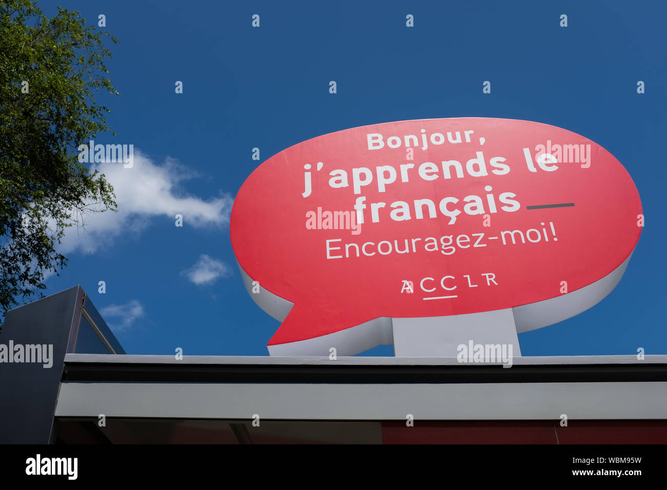 Signe sur un arrêt de bus d'encourager les gens à interagir dans la langue française avec des immigrants au Québec, Montréal Quartier chinois Banque D'Images