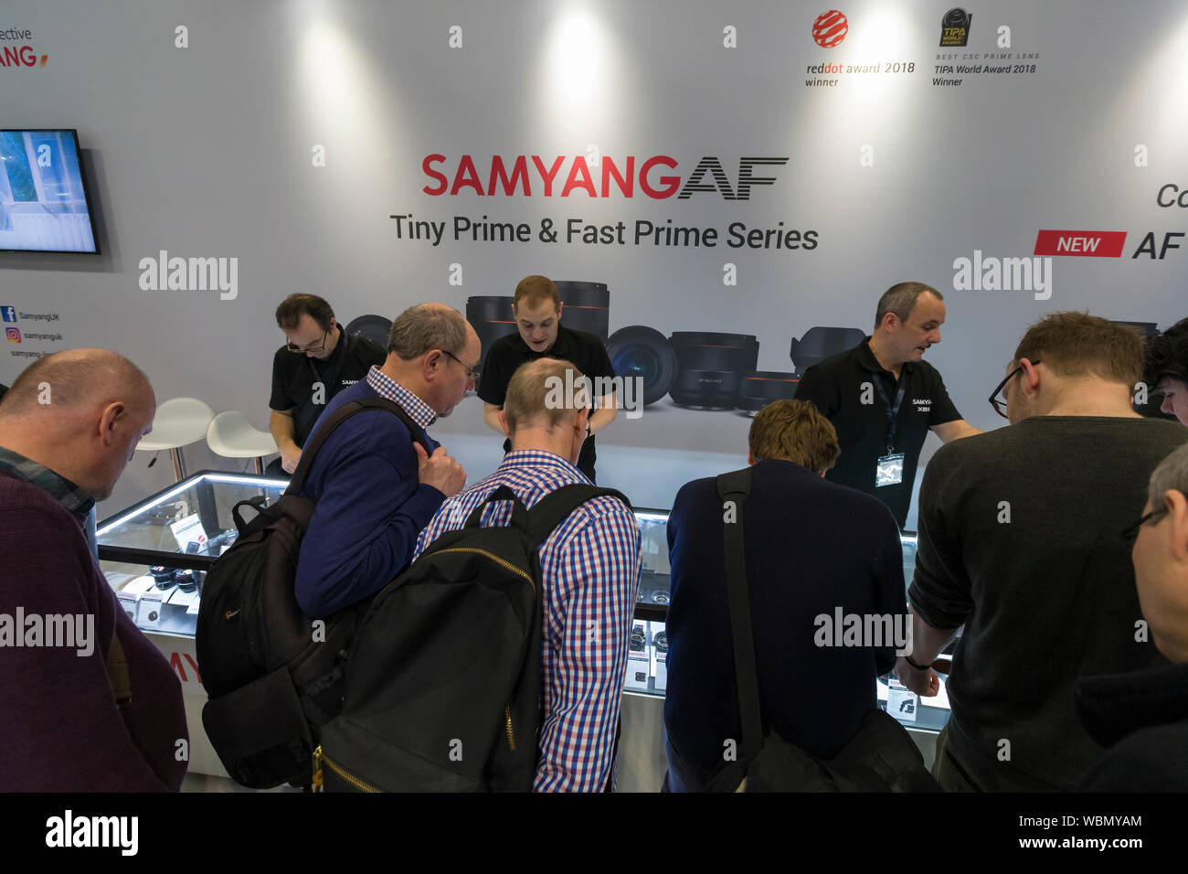 Samyang stand AF, les membres de l'équipe de parler aux visiteurs, la photographie montre 2019, Birmingham, Royaume-Uni Banque D'Images