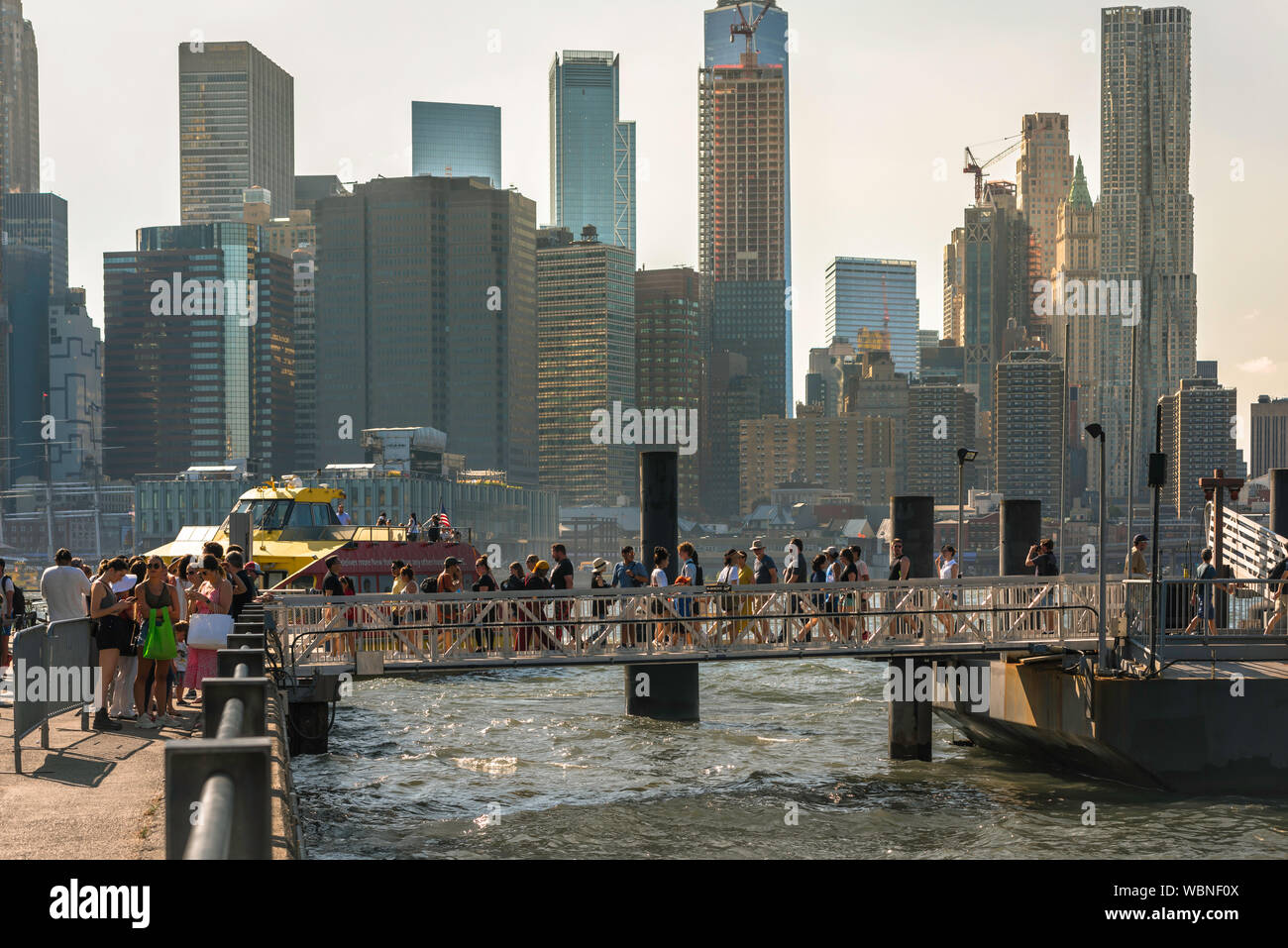 Ferry East River, vue en été de personnes traversant le pont d'embarquement de l'East River en ferry du Port de Brooklyn, New York City, USA Banque D'Images