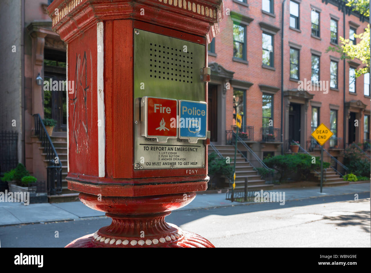 New York Brooklyn Street, vue d'une boîte d'appel d'urgence située dans une rue de bâtiments résidentiels en grès brun à Brooklyn Heights, New York City, États-Unis Banque D'Images