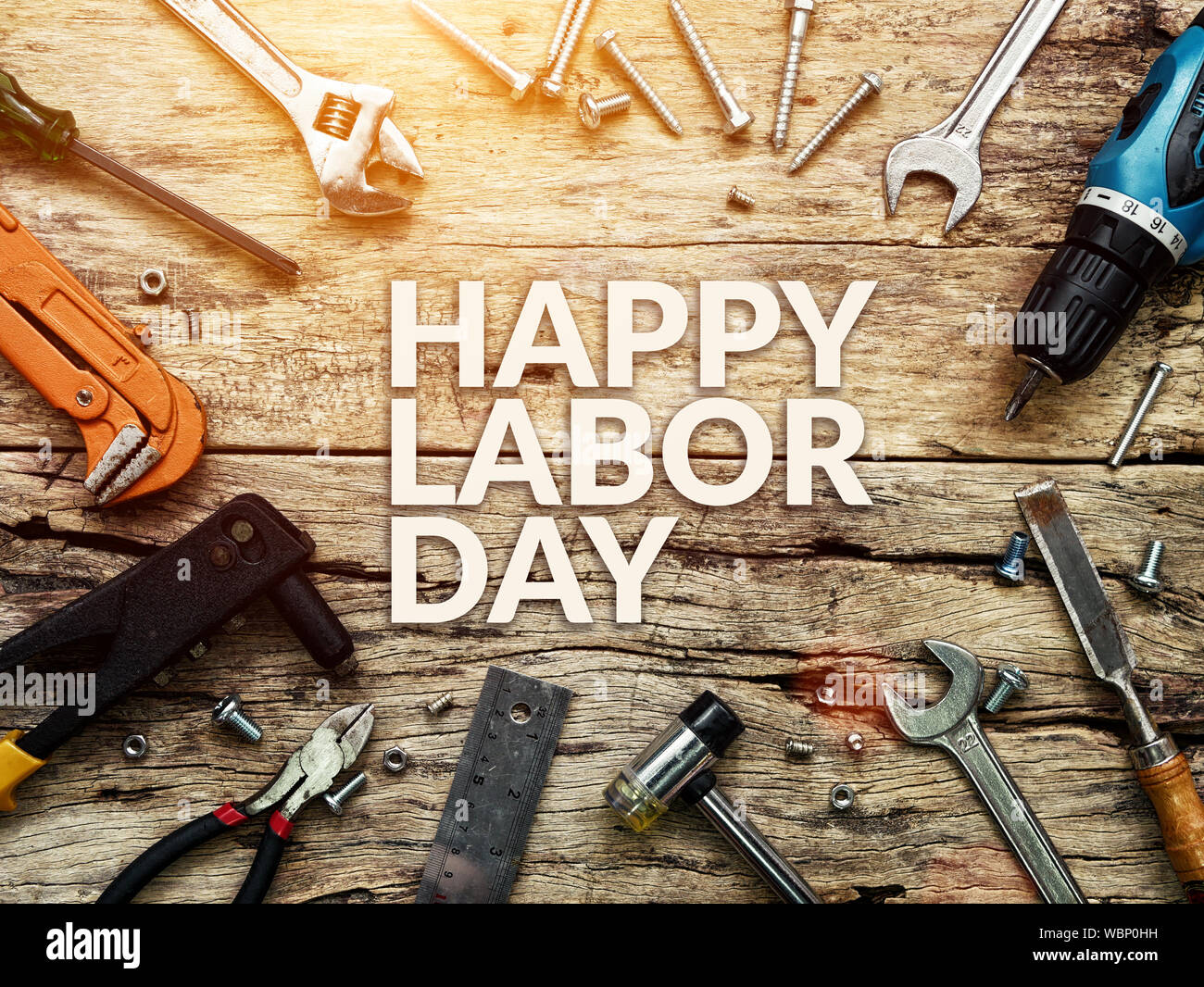 Heureuse fête du travail texte en blanc sur fond de bois de construction avec des outils de réparation. Banque D'Images