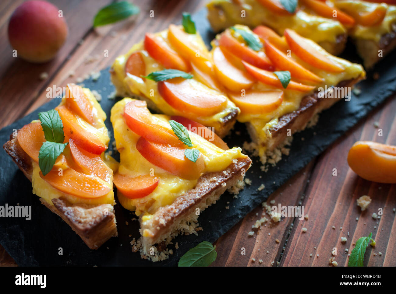 Close-up d'abricot fait maison tarte avec la crème pâtissière et de menthe fraîche Banque D'Images