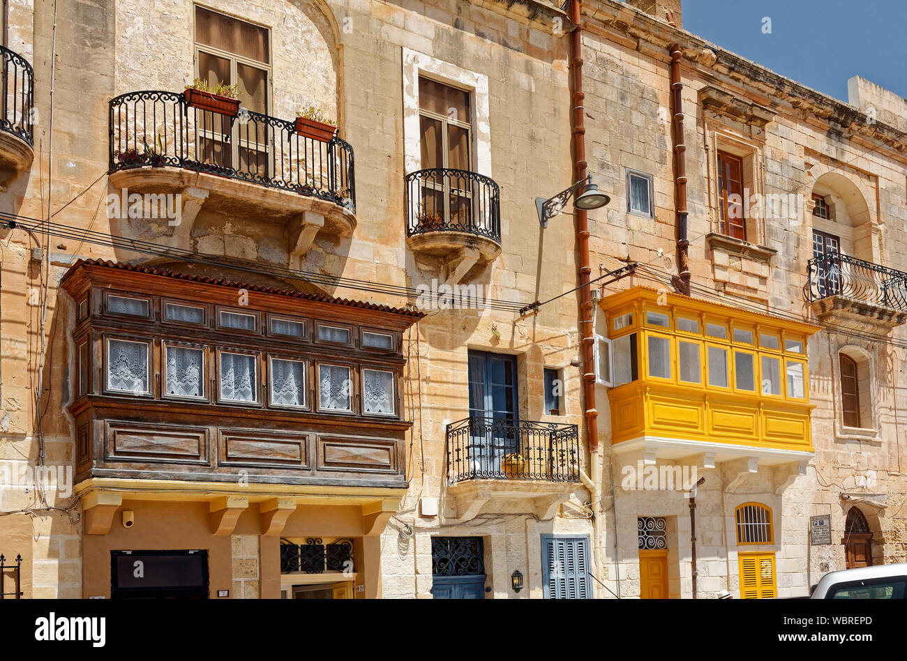 D'un balcon, de style maltais ci-joint, en fer forgé, scène de rue ; vieux bâtiments en pierre calcaire ; Europe ; Birgu, Vittoriosa ; Malte ; printemps ; horizontal Banque D'Images