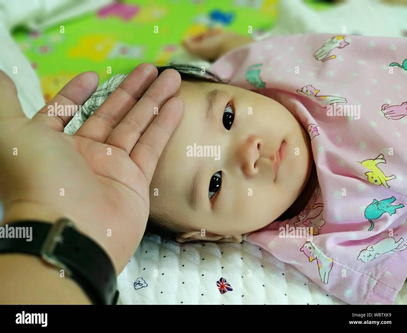 Portrait de la personne touchant le front de fille de bébé à la maison  Photo Stock - Alamy