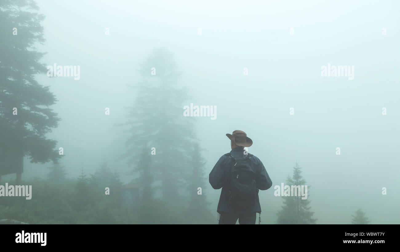 Voyageur touriste masculin dans les montagnes et s'intéresse à l'épais brouillard, Banque D'Images Voyageur touriste masculin dans les montagnes et s'intéresse à l'épais brouillard, Banque D'Images