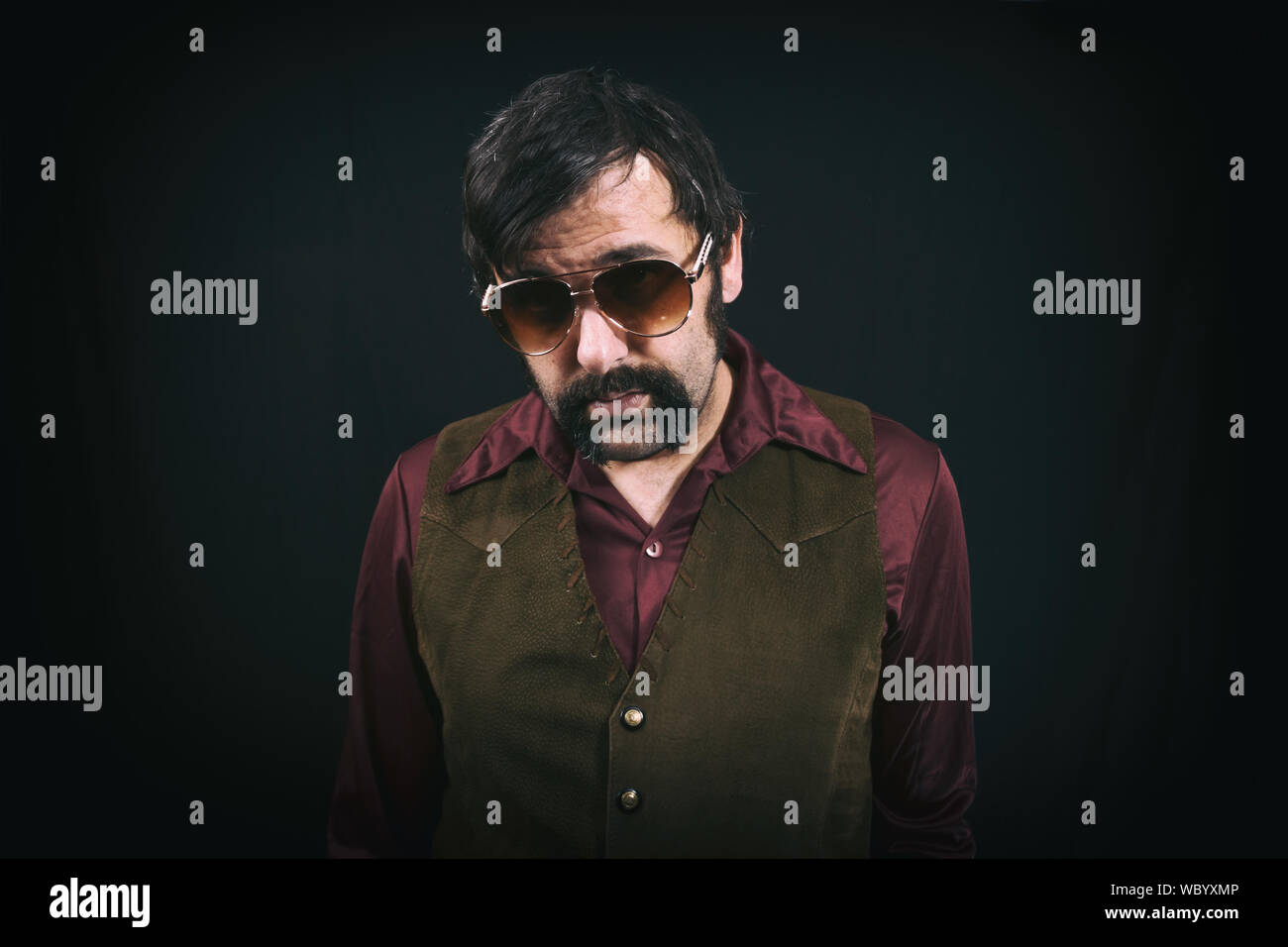 Homme vêtu de vêtements vintage des années 70, ère avec de grands colliers,  moustache, une veste en cuir et des lunettes de soleil Photo Stock - Alamy