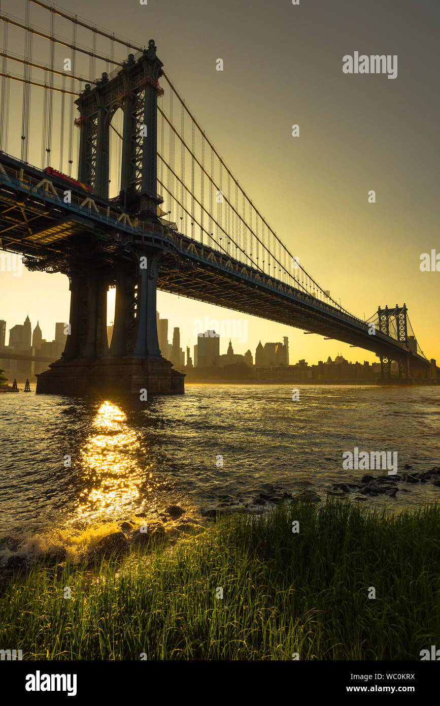 New York, vue du pont de Brooklyn au coucher du soleil de pont de Manhattan avec la skyline de Manhattan dans la distance, New York City, USA Banque D'Images