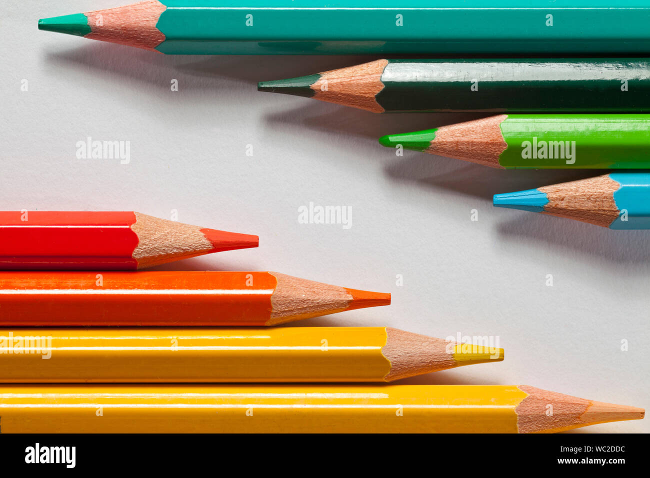 Jaune, rouge, vert et bleu sur fond blanc crayons ou abstrait arrière-plan de l'éducation Banque D'Images