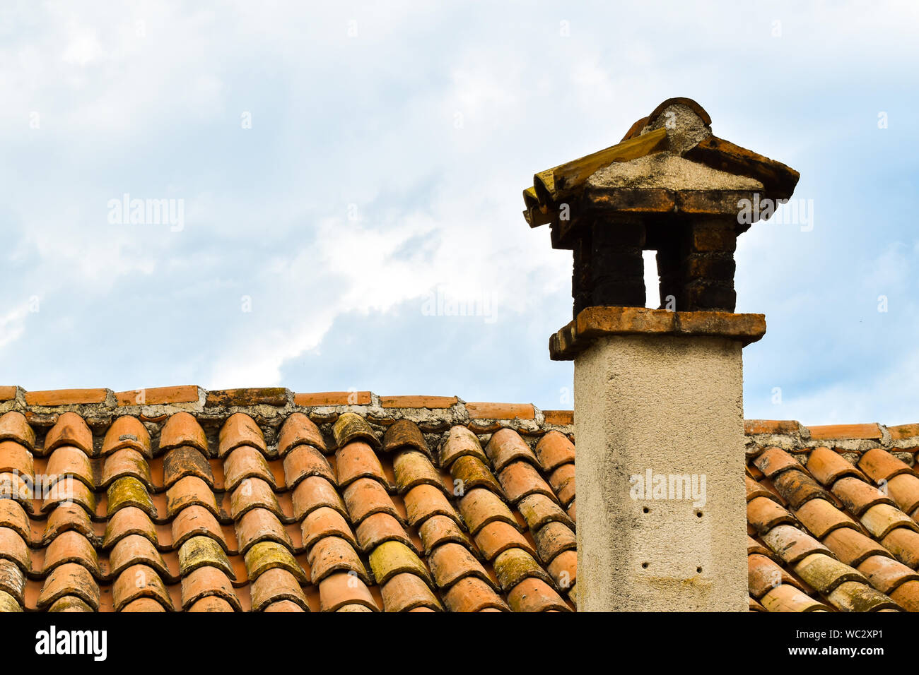 Close up shot of old orange toit avec tuiles d'argile et de cheminée. Toit de l'ancienne maison en Croatie Banque D'Images