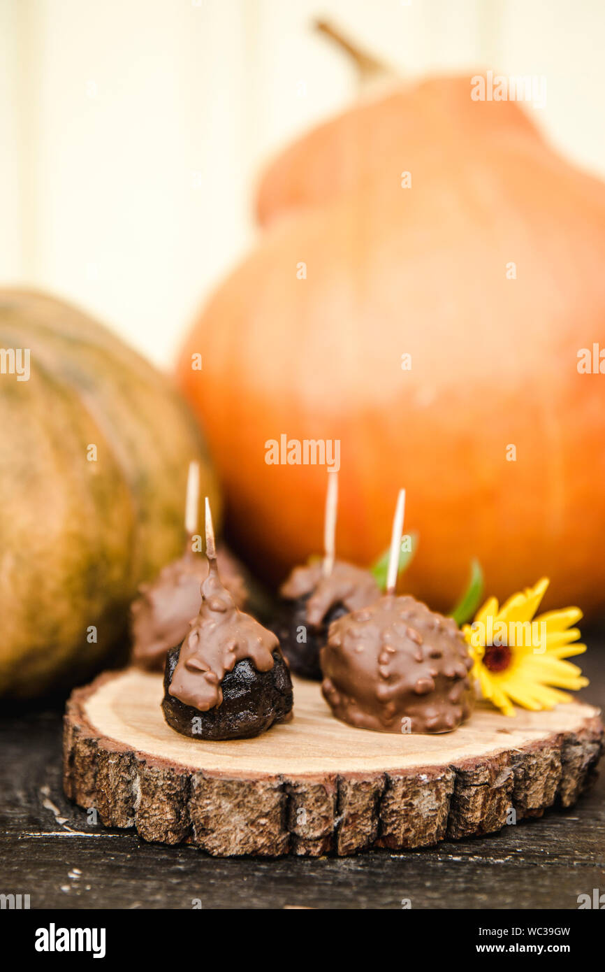 Selective focus on chocolat artisanal avec bonbons citrouilles orange sur le contexte à l'automne. Banque D'Images