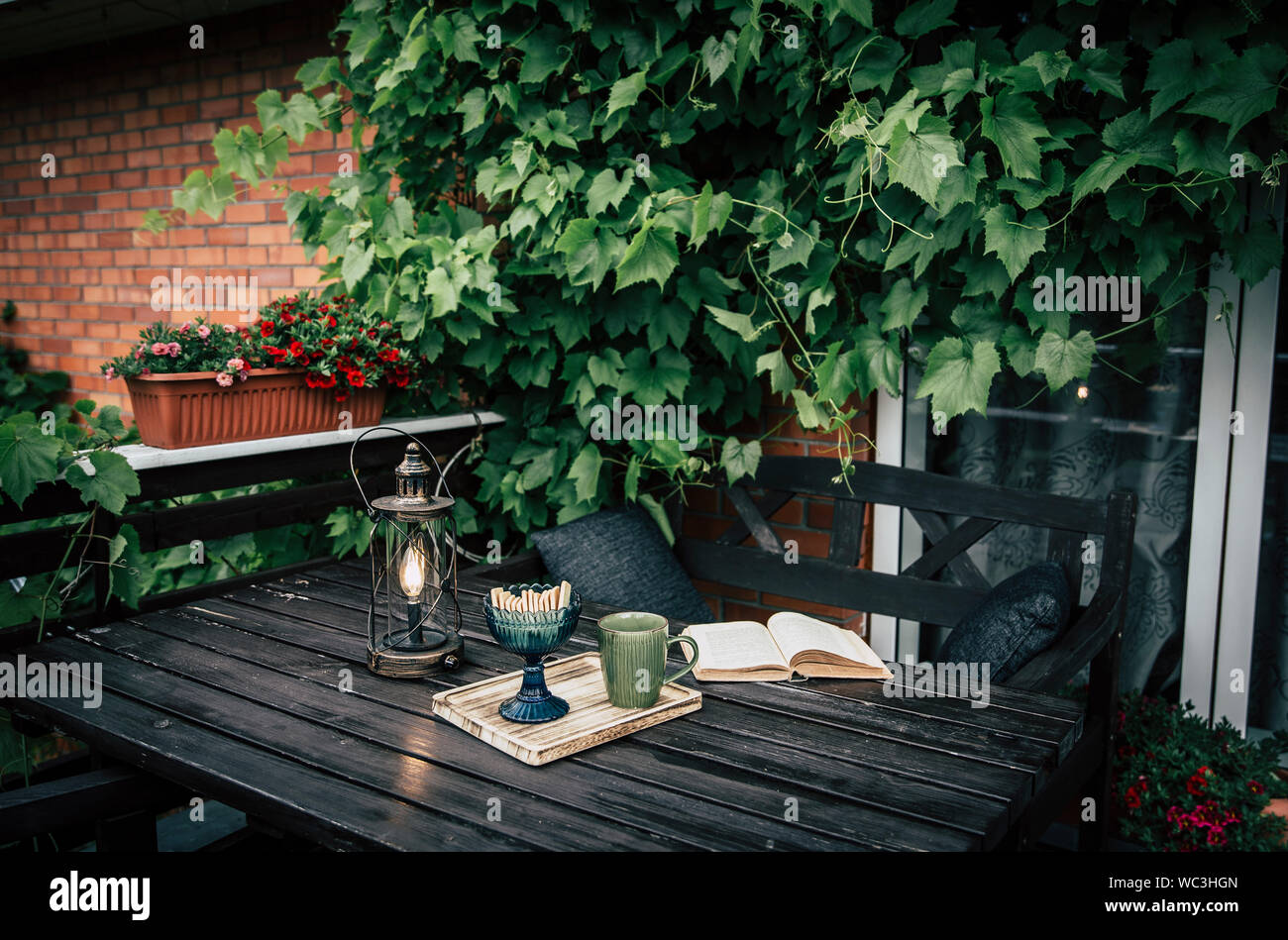 Balcon privé en plein air avec des vignes d'Escalade sur mur, brown mobilier de jardin, de boissons, de cookies. mug Moderne vie Instagram Banque D'Images