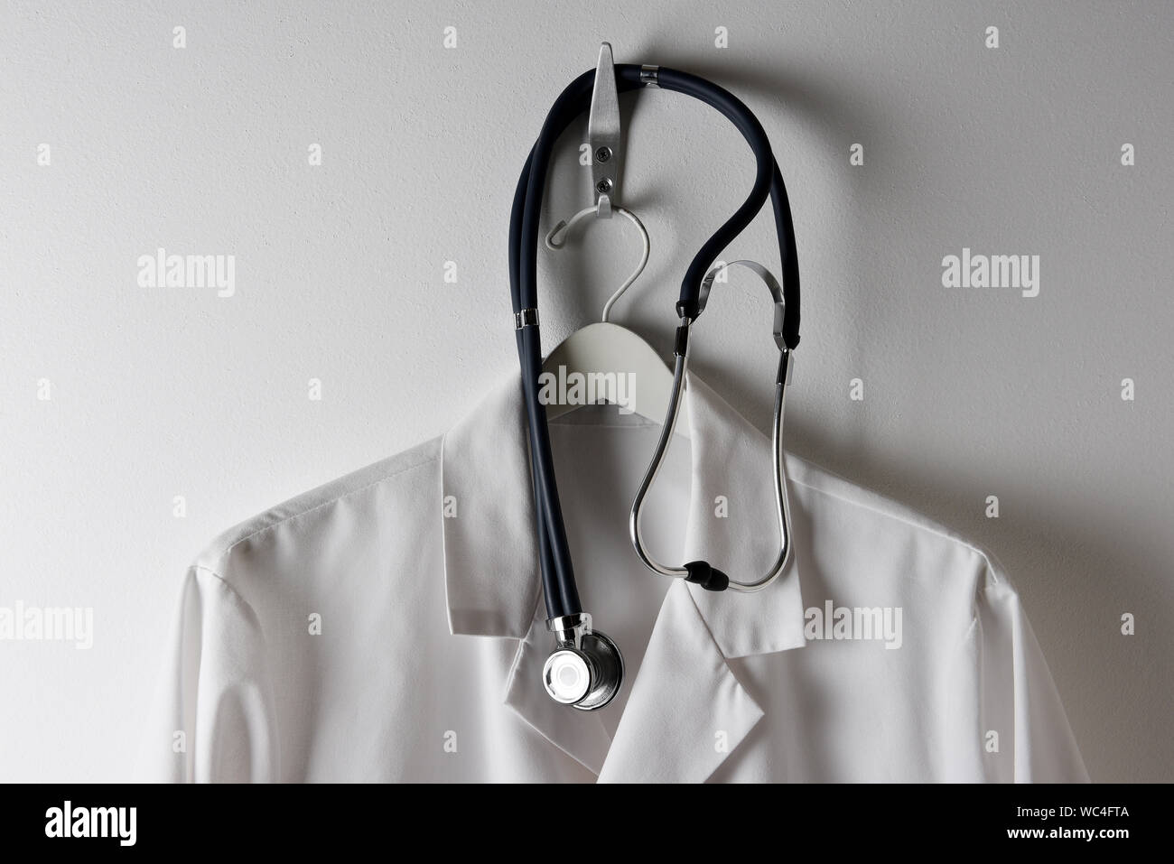 Libre de médecins sarrau blanc suspendu à un crochet avec stéthoscope, à l'horizontale. Banque D'Images