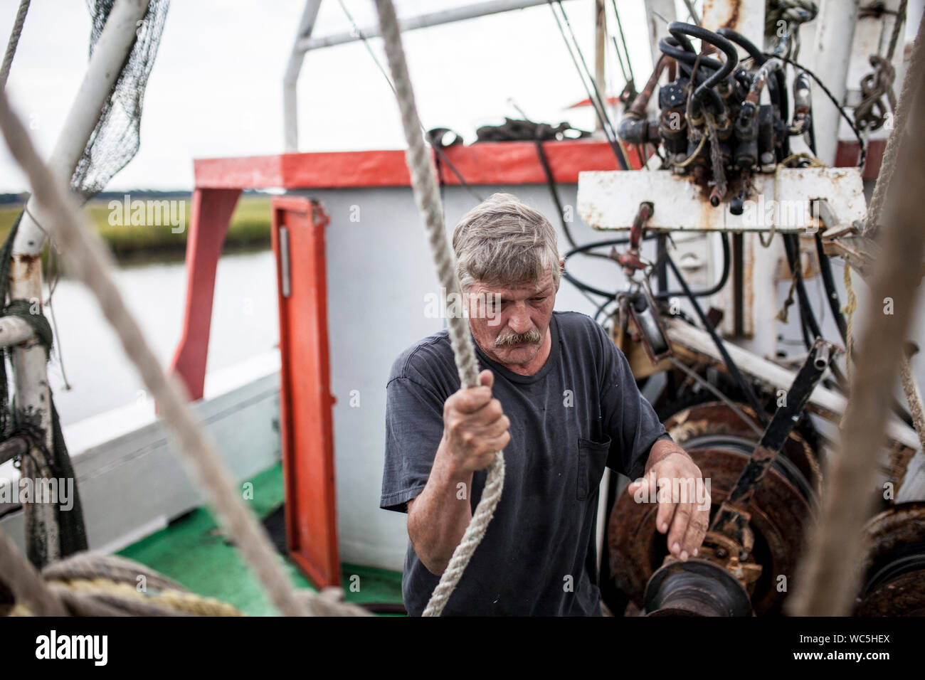 Matelot altérés travaillant sur le pont d'un bateau de pêche Banque D'Images