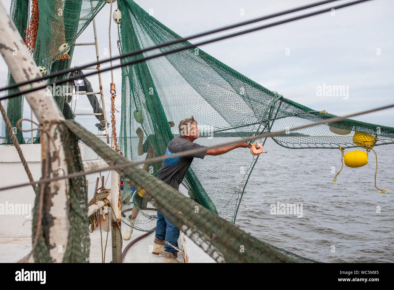 Les pêcheurs commerciaux qui tendent des filets sur navire de pêche commerciale Banque D'Images