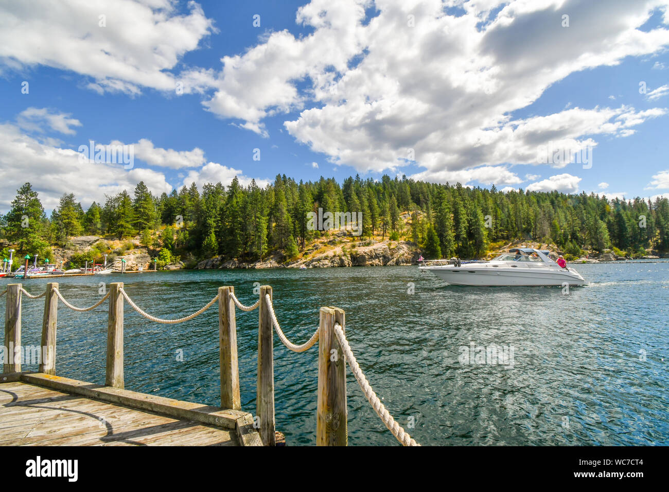 Un hors-bord de luxe croisières passé Tubbs Hill près de la station de l'ADC et trottoir flottant dans la ville de montagne de Coeur d'Alene Idaho. Banque D'Images