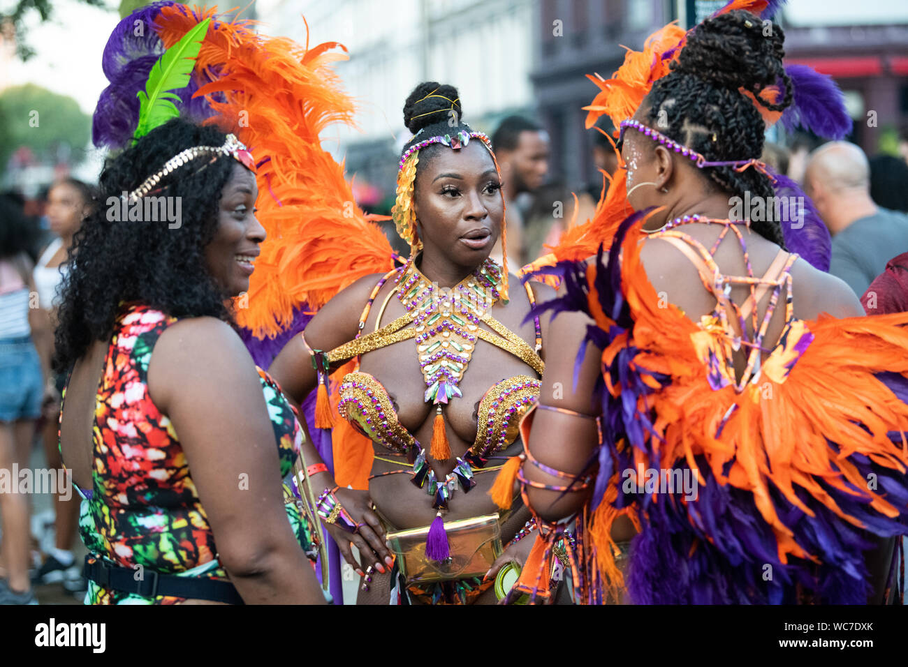 Danseuses en conversation sur la rue pendant la carnaval de Notting Hill, plus grand festival d'Europe. Banque D'Images