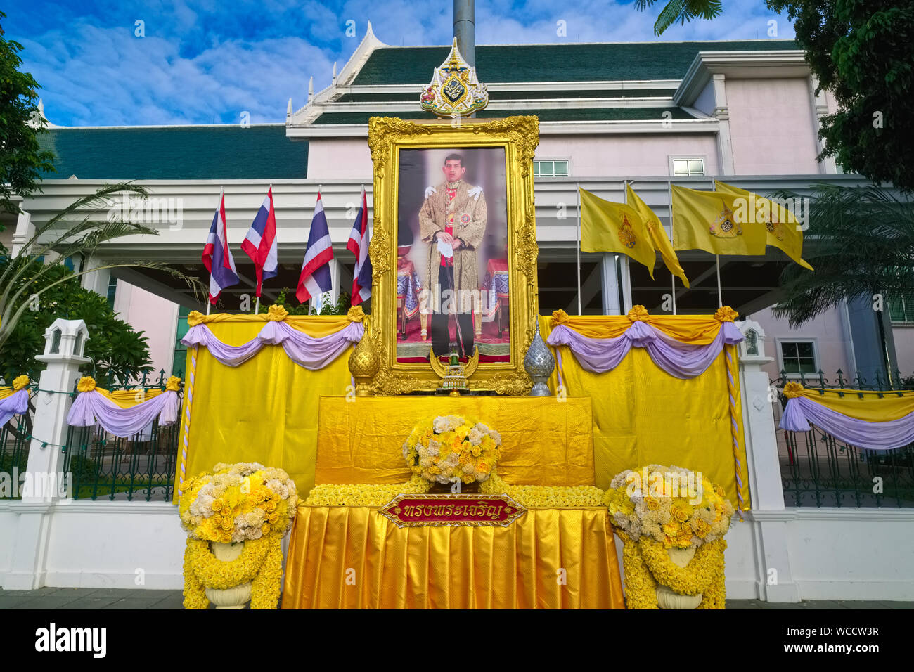Portrait d'un roi thaïlandais Maha Vajiralongkorn encadrée par des drapeaux thaïlandais (l) et des drapeaux symbolisant la monarchie (r), à un govt. Bldg., Bangkok, Thaïlande Banque D'Images