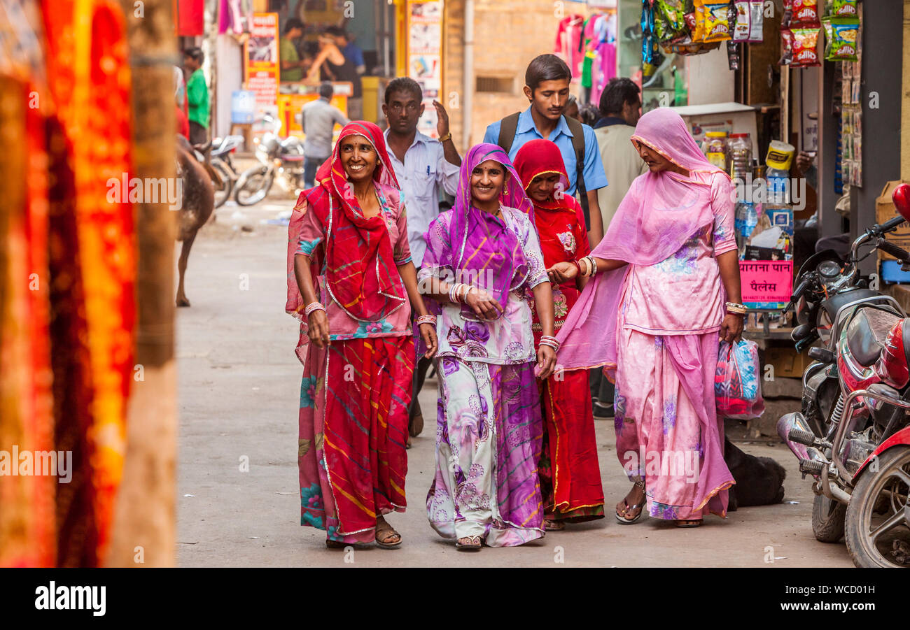 Quatre femmes marchant dans une rue de Jaisalmer, Rajasthan, Inde dans leurs vêtements colorés. Banque D'Images