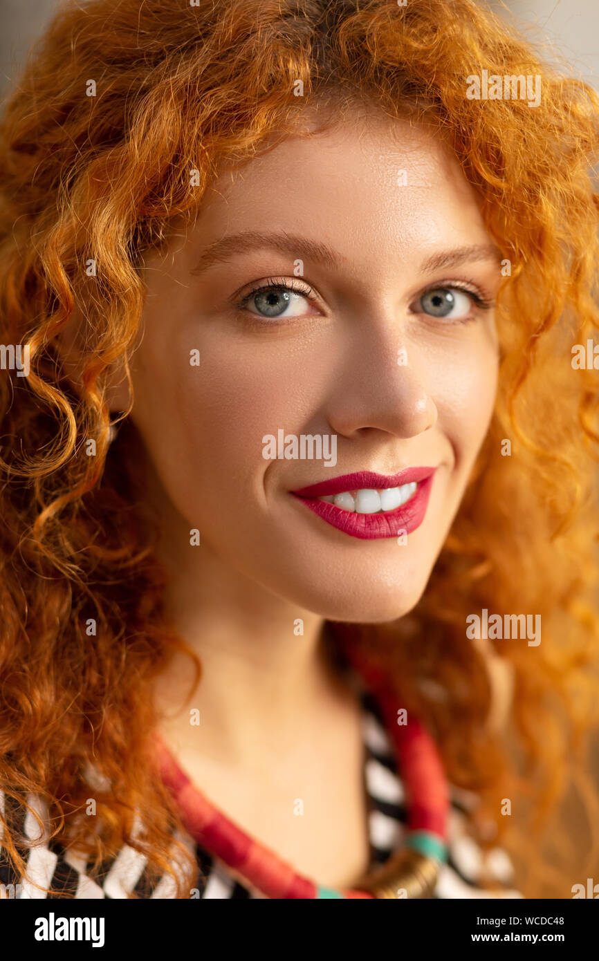 Close up of blue-eyed curly femme motivé pour travailler Banque D'Images