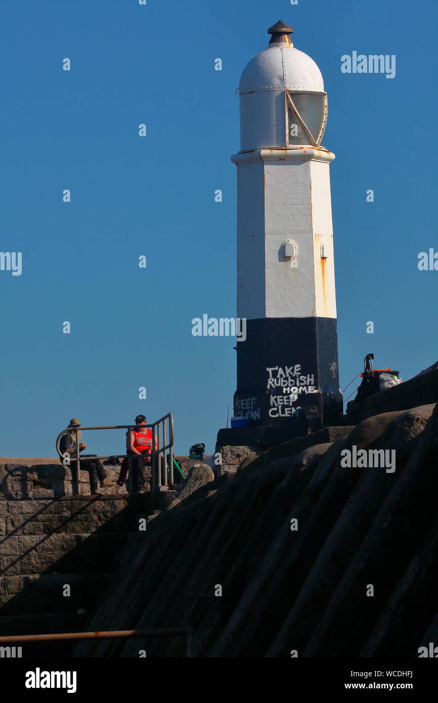 Le vieux phare à l'extrémité de la jetée de Porthcawl, célèbre pour ses hautes vagues durant les tempêtes qui dépassent de loin les deux étages adjacents. Banque D'Images