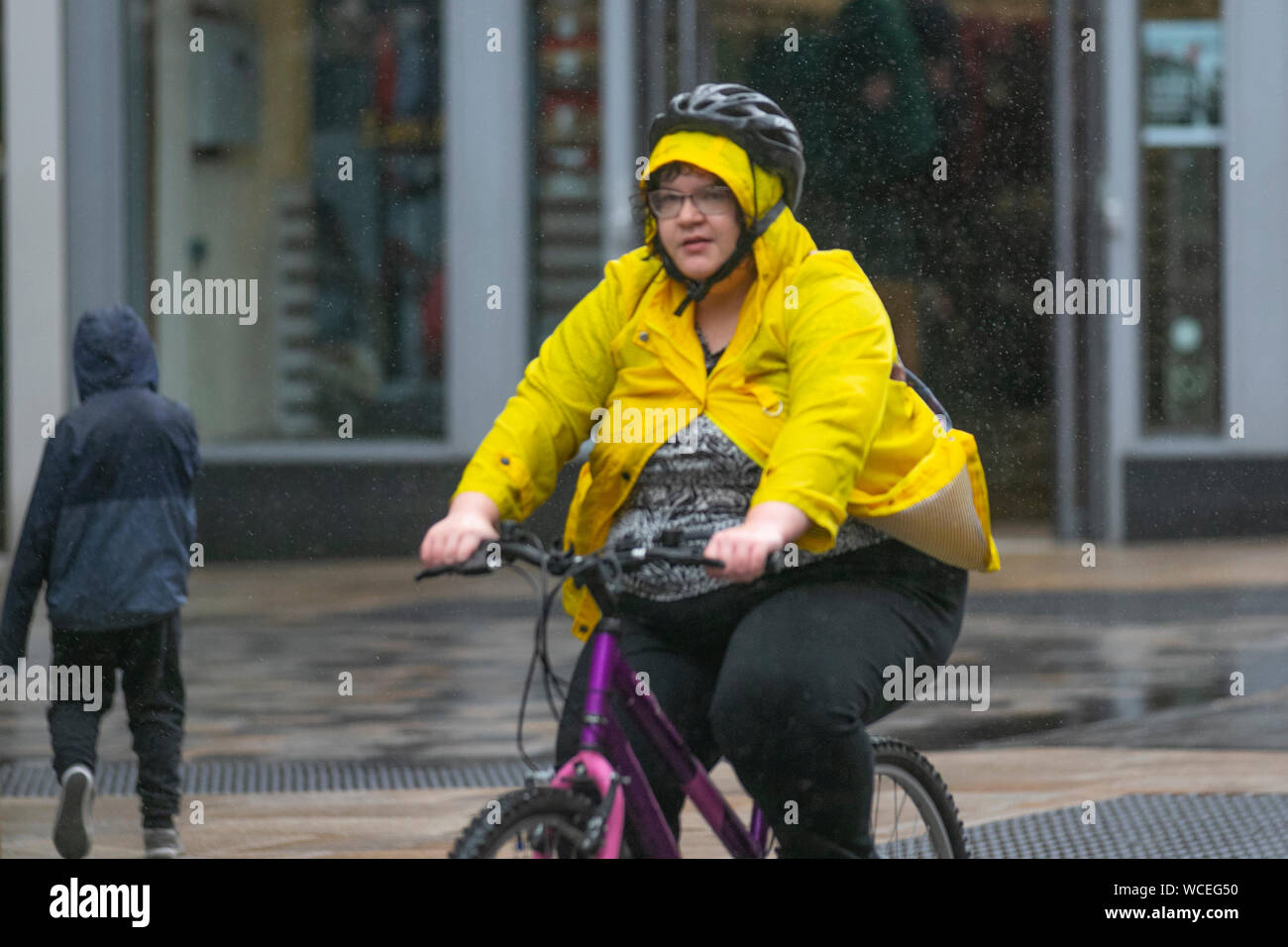 Femme obèse, en surpoids femme sur un vélo à Preston, Lancashire. 28 août  2019 Météo France. L'été torride se termine avec de fortes averses dans la  région de Preston. Credit : MediaWorldImages/Alamy
