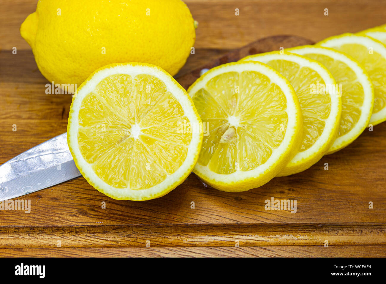 Fruits frais citron jaune avec demi-coupe sur le bois pour les jours chauds d'été et bon pour la santé Banque D'Images