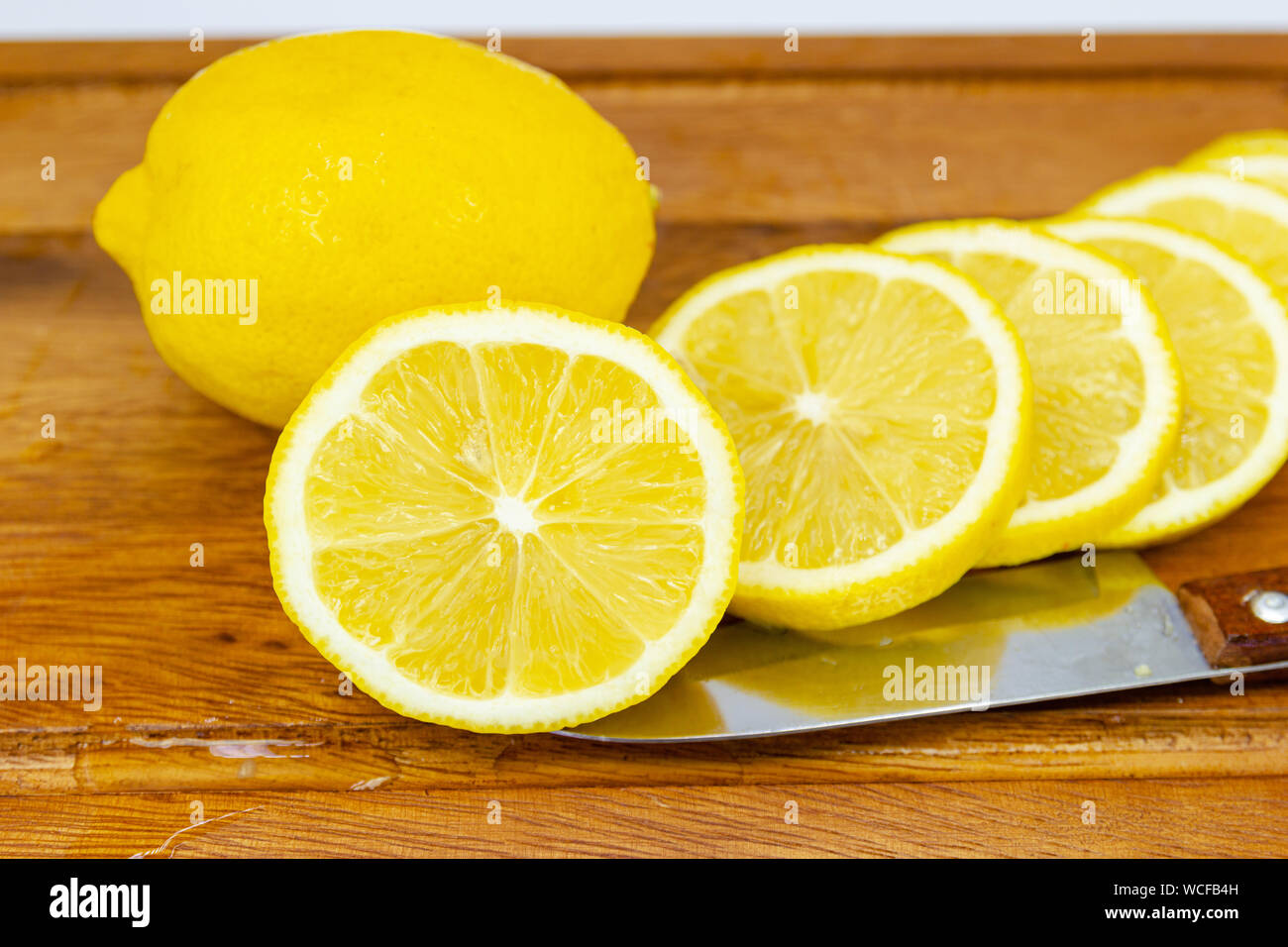 Fruits frais citron jaune avec demi-coupe sur le bois pour les jours chauds d'été et bon pour la santé Banque D'Images