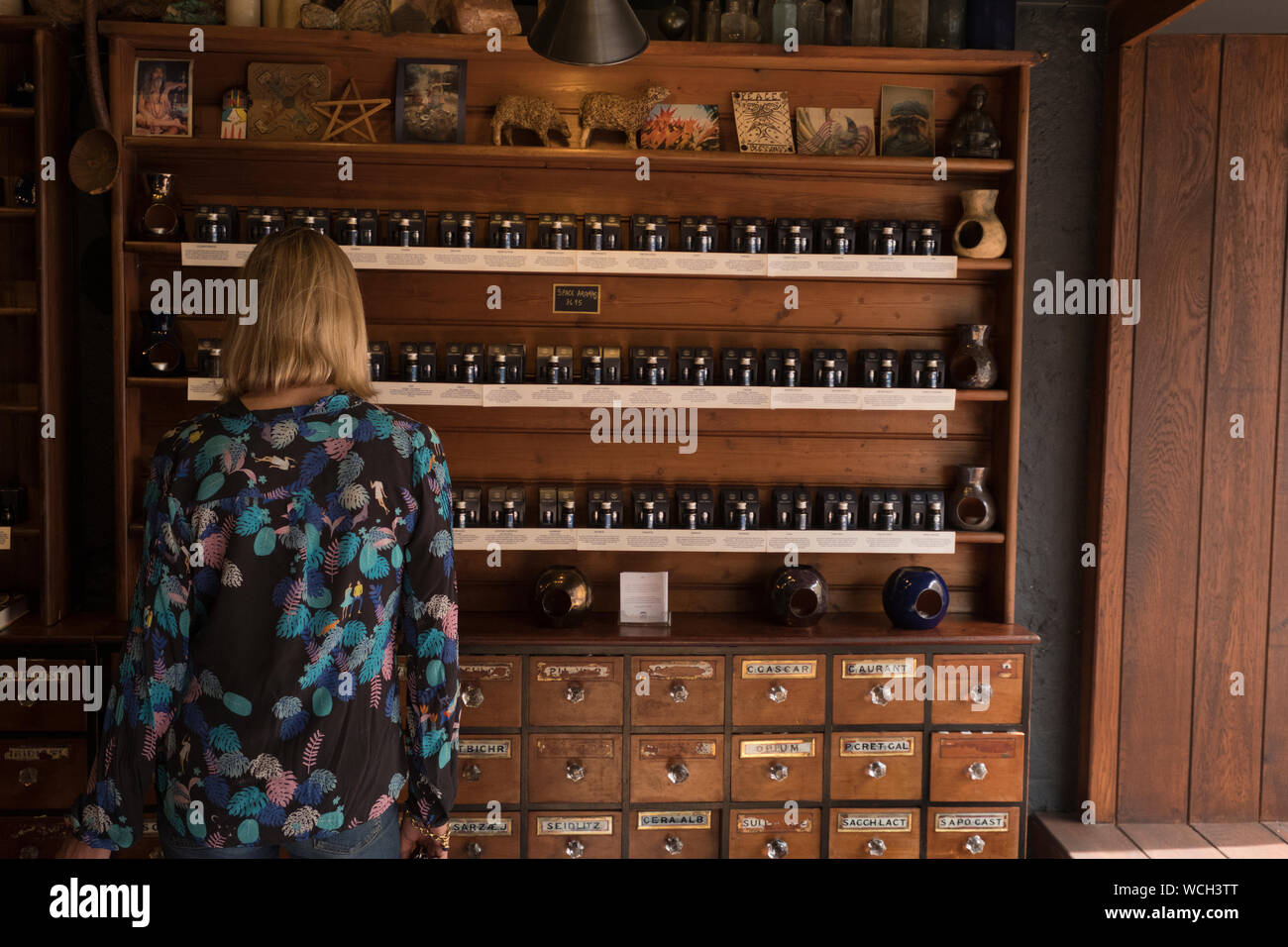 Femme dans magasin de potions dans le centre du village de Glastonbury dans le Somerset en été Banque D'Images