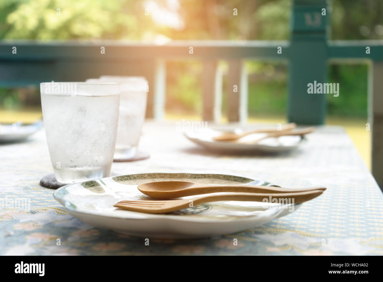 Fourchette et cuillère sur plaques de verre en buvant sur table au porche Banque D'Images