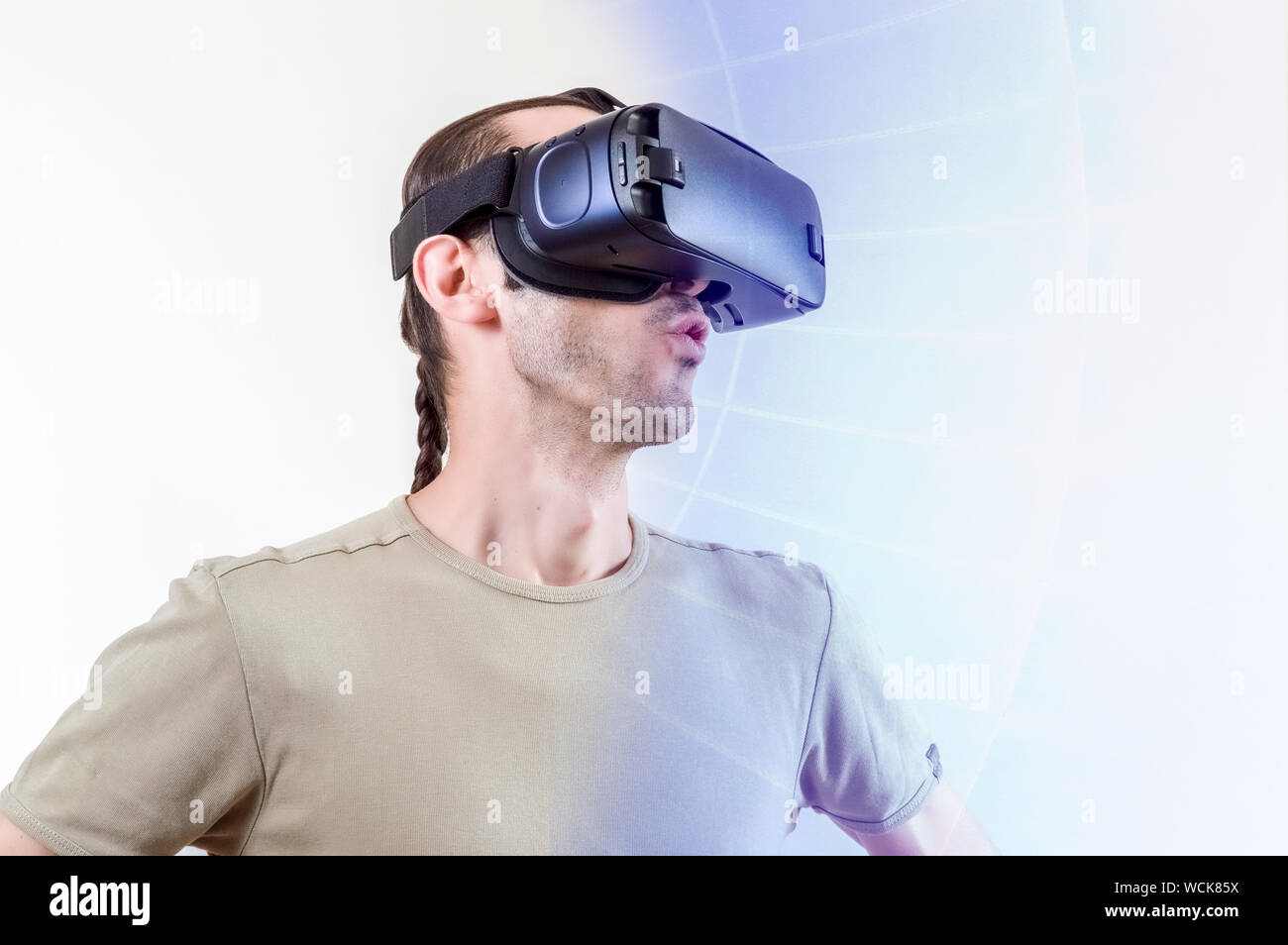 Man dans t-shirt portant des lunettes de réalité virtuelle sur fond blanc. La future technologie concept. Banque D'Images