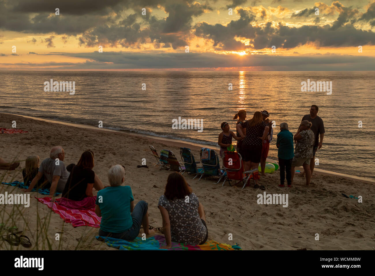 Union Pier, Michigan - Les gens se rassemblent sur la plage alors que le soleil se couche sur le lac Michigan. Banque D'Images