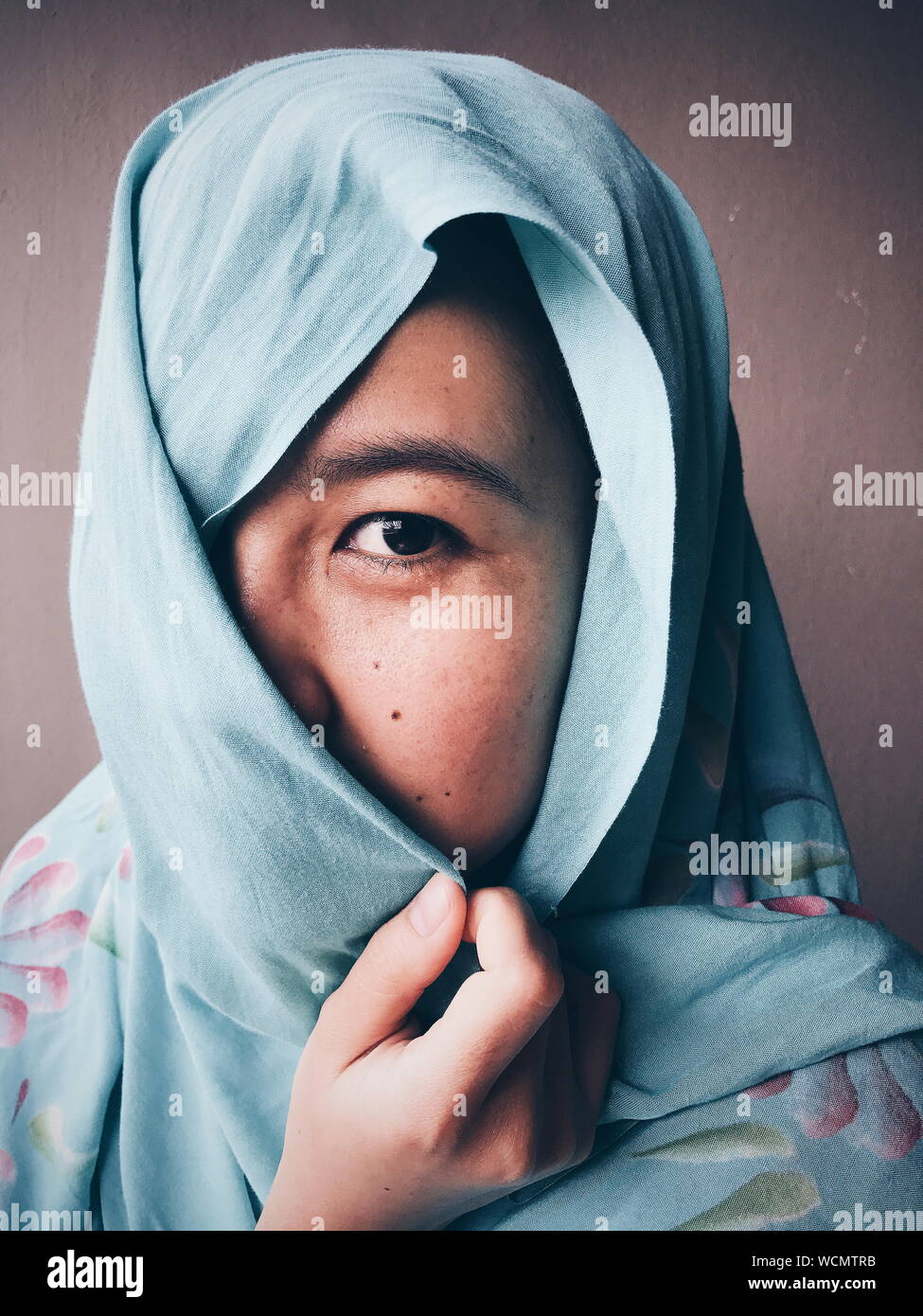 Close-up Portrait of Woman Wearing Hijab contre mur Banque D'Images