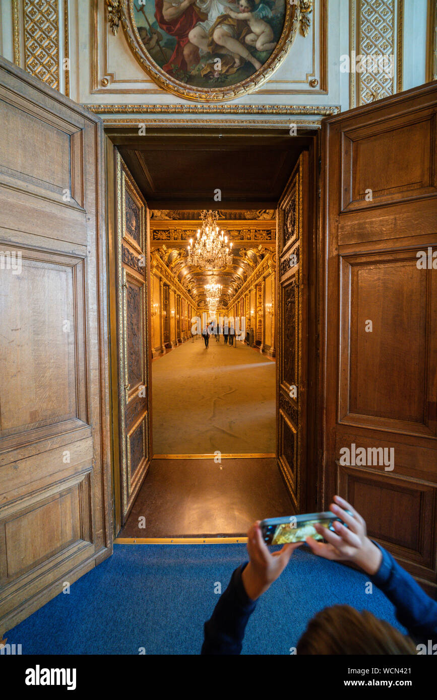 Enfant avec smartphone photographiant le couloir décoré et peintures piscine le Palais Royal, Stockholm, Suède Banque D'Images