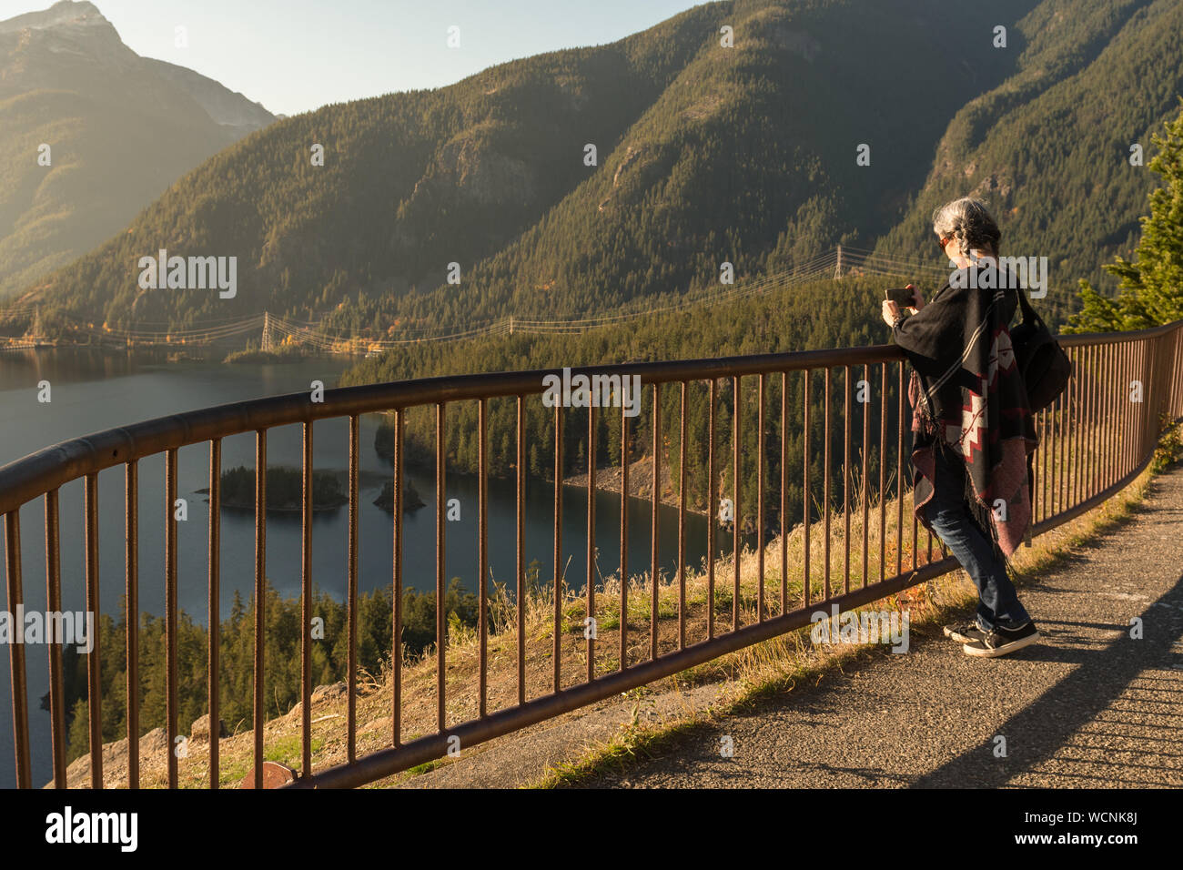 Une jeune femme aux cheveux blancs prend des photos avec son smartphone de Diablo Lake, dans la région de North Cascades Banque D'Images