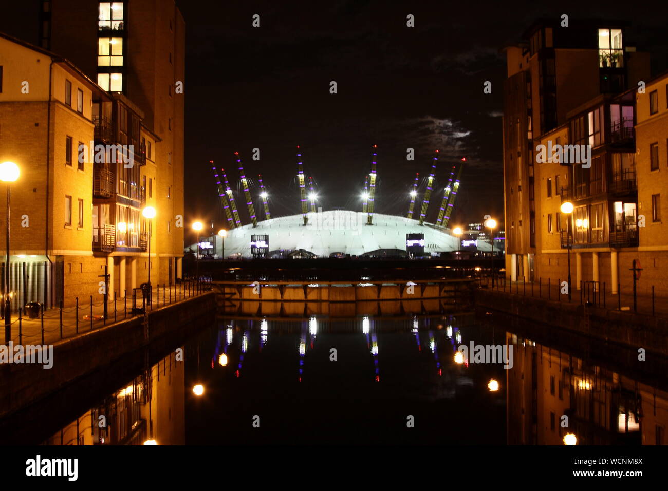 O2 Arena VUE DEPUIS L'ISLE OF DOGS, EST DE LONDRES LA NUIT. La MUSIQUE ET AUTRES DIVERTISSEMENTS SITUÉ SUR LA PÉNINSULE DE GREENWICH, AU SUD-EST DE LONDRES. Anciennement connu sous le Millennium Dome , LE DÔME ET NORTH GREENWICH ARENA.. La musique la plus fréquentée au monde. Adidas lumière néon publicité PRÈS DE ARENA. Banque D'Images