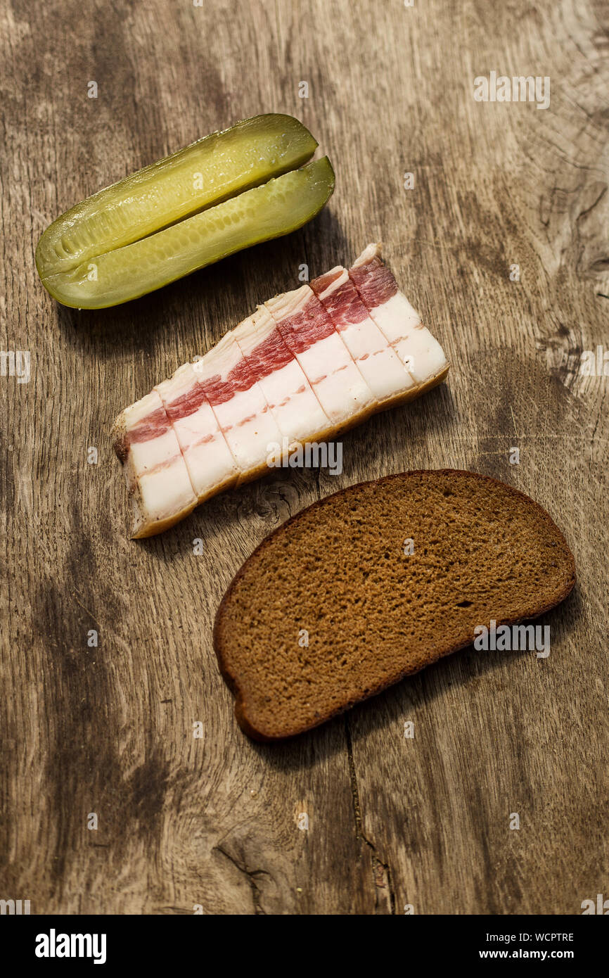 Du bacon, du pain et de concombre sur fond de bois. Apéritif traditionnel russe et ukrainien Banque D'Images