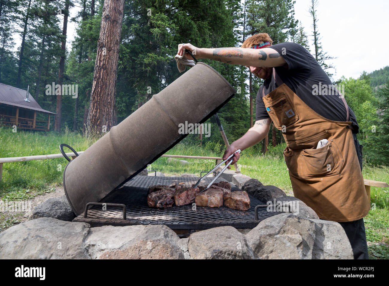 Longe de porc cuisson sur un feu à l'Minam River Lodge dans les montagnes de l'Oregon Wallowa. Banque D'Images