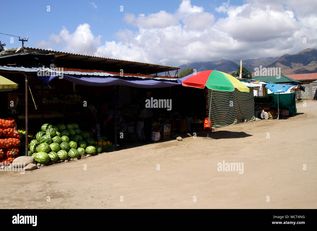 Échoppe de marché à Cholpon Ata protégés contre le soleil de midi, avec les montagnes en arrière-plan Banque D'Images