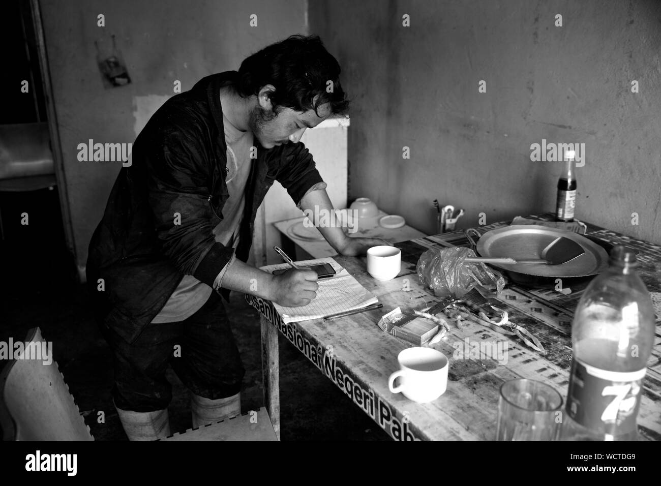 Plantation de thé Bharat, Cameron Highlands, Malaisie : Homan calembour de l'âge de 22 ans est de Macd jilla, Bhakimli Dhawlagiri, au Népal. Il est en train d'envoyer de l'argent à sa famille au Népal. Il a été à l'emploi de thé Bharat pendant environ 6 mois. Dans la première moitié de la journée, il travaille sur le terrain, couper toutes les plantes indésirables et la deuxième moitié il conduit le tracteur. Il gagne environ 1500-1600 $/mois. Il n'a pas de couverture santé. Il a payé la main-d'oeuvre à Katmandou 50 000 NPR pour obtenir cet emploi. Envoyé de l'argent Accueil deux fois en 2 mois. 850 $ la première fois et 500 $ la deuxième fois 'Dici dukh garera Banque D'Images