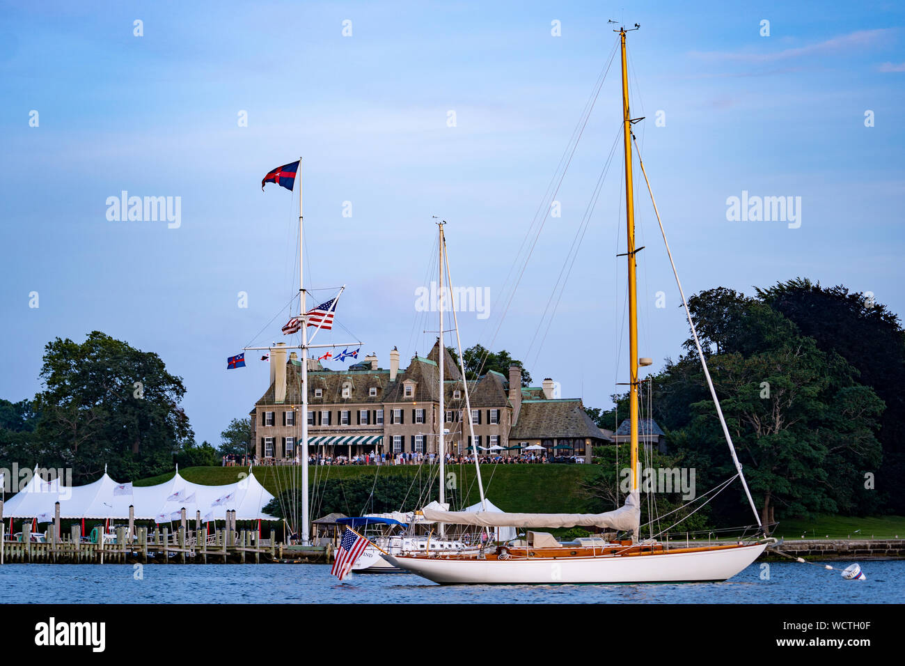 Yacht à voile en bois classique amarré devant le clubhouse Harbour Court du New York Yacht Club, Newport, Rhode Island, États-Unis. Banque D'Images