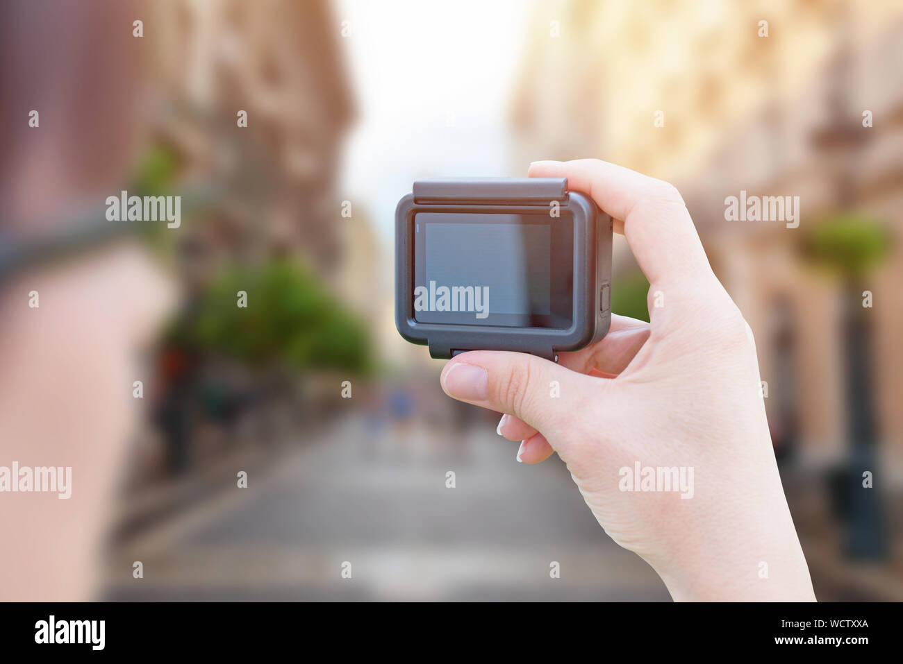 Influenceur rend la vidéo avec caméra action in city street concept. Banque D'Images