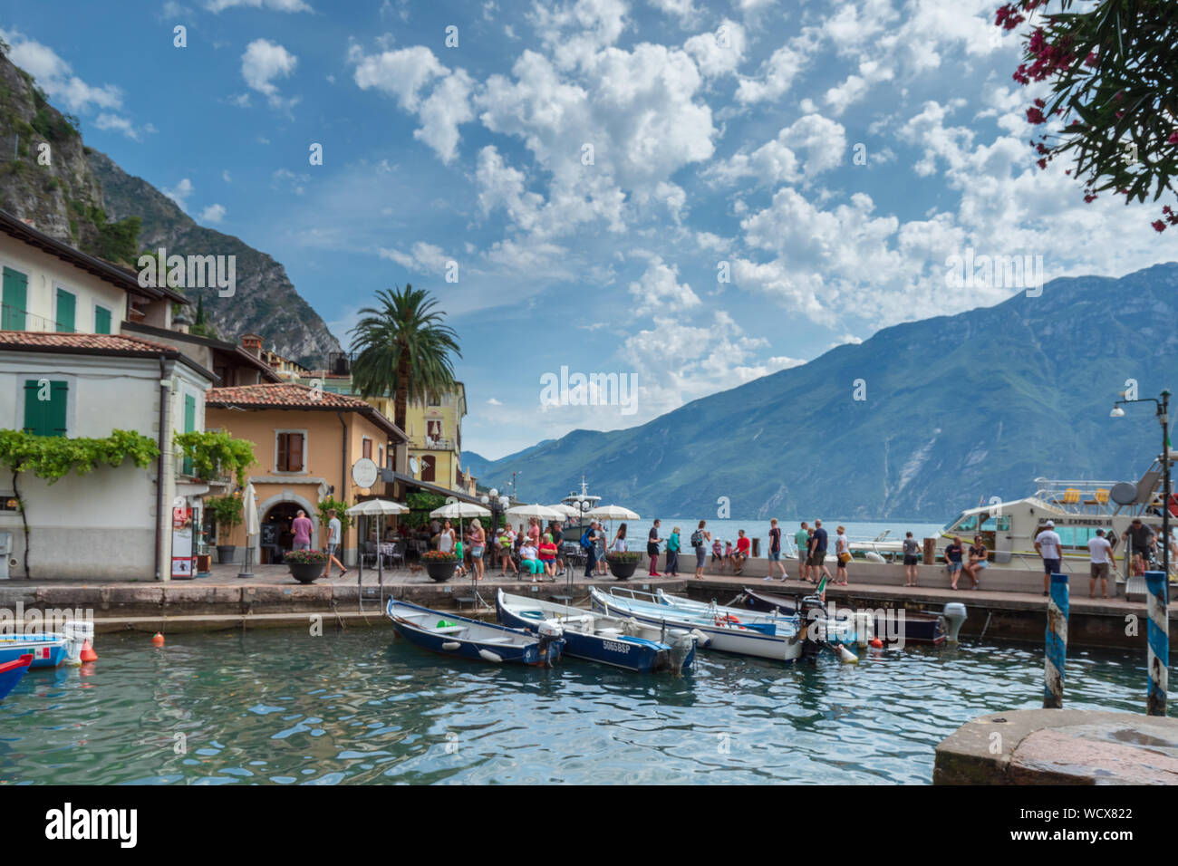 Bateaux dans le vieux port de Limone sul Garda, sur le lac de garde sous un ciel bleu. Banque D'Images