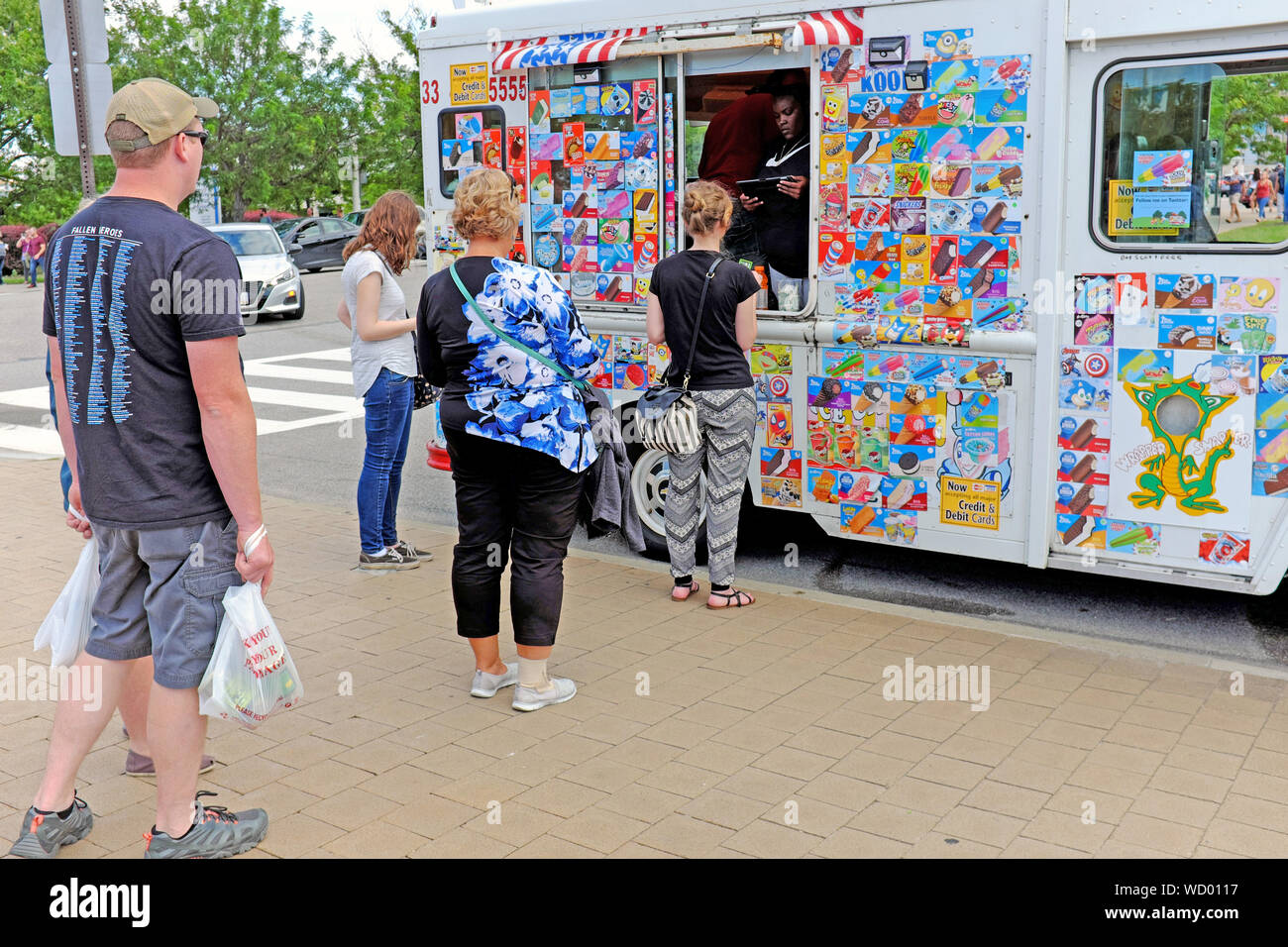 Les adultes attendent en ligne un camion de glace mobile côté rue lors d'une chaude journée d'été à Washington, DC, USA. Banque D'Images