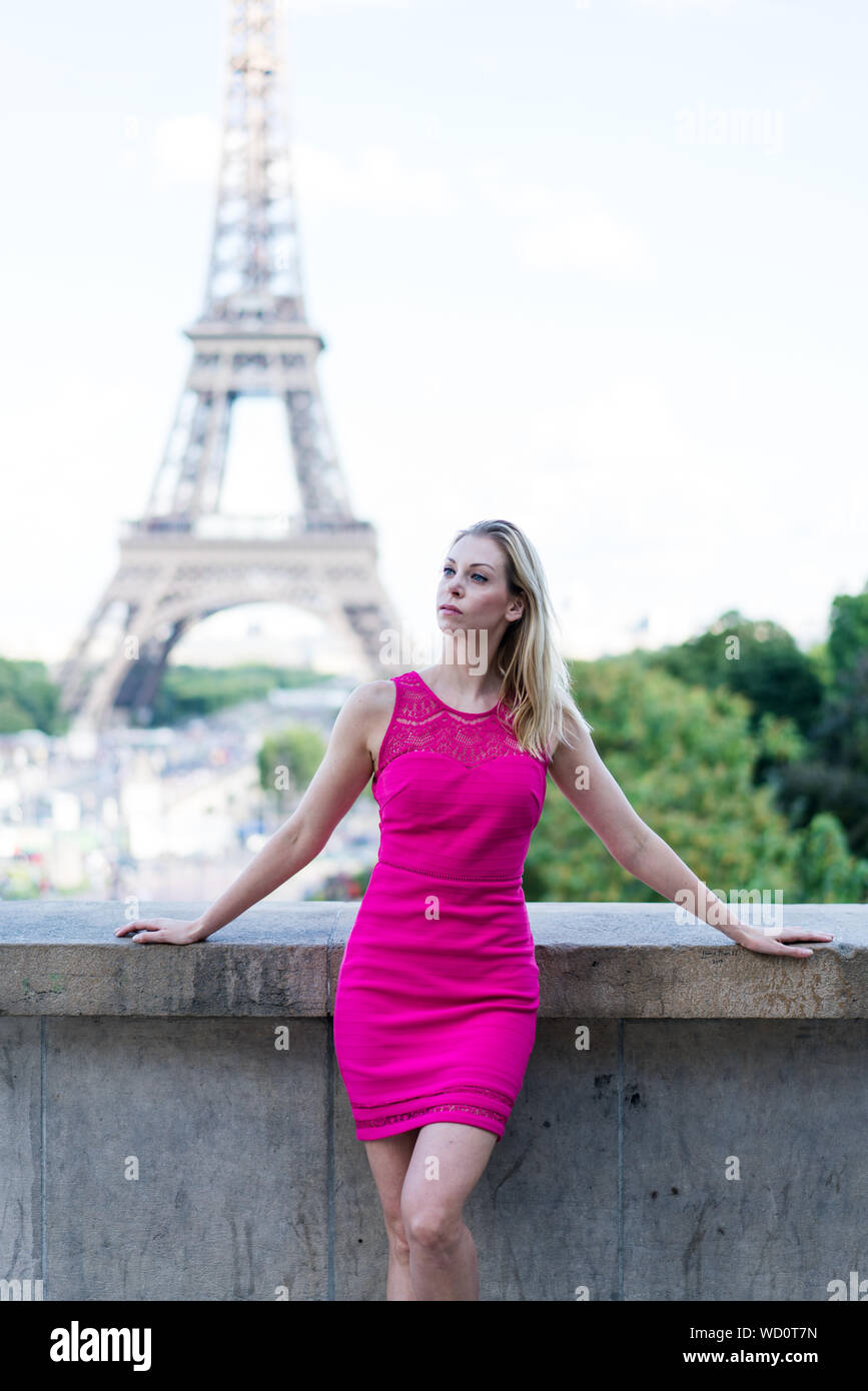 Paris, France - le 2 juillet 2017 : jeune femme blonde avec robe rose et  chaussures rose debout, Tour Eiffel et ciel bleu en arrière-plan Photo  Stock - Alamy