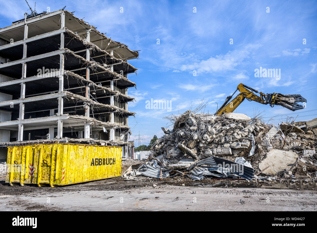 Bâtiment Maison démolition Pelle hydraulique avec site machine crasher et récipient jaune avec écrit abbruch est l'allemand pour la démolition Banque D'Images
