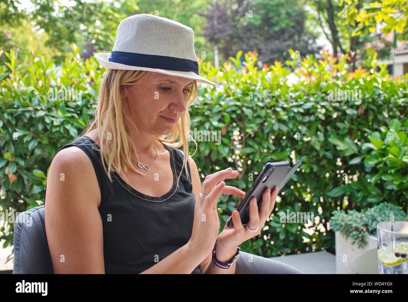 Portrait de la jeune femme avec chapeau de sms sur le téléphone mobile Banque D'Images