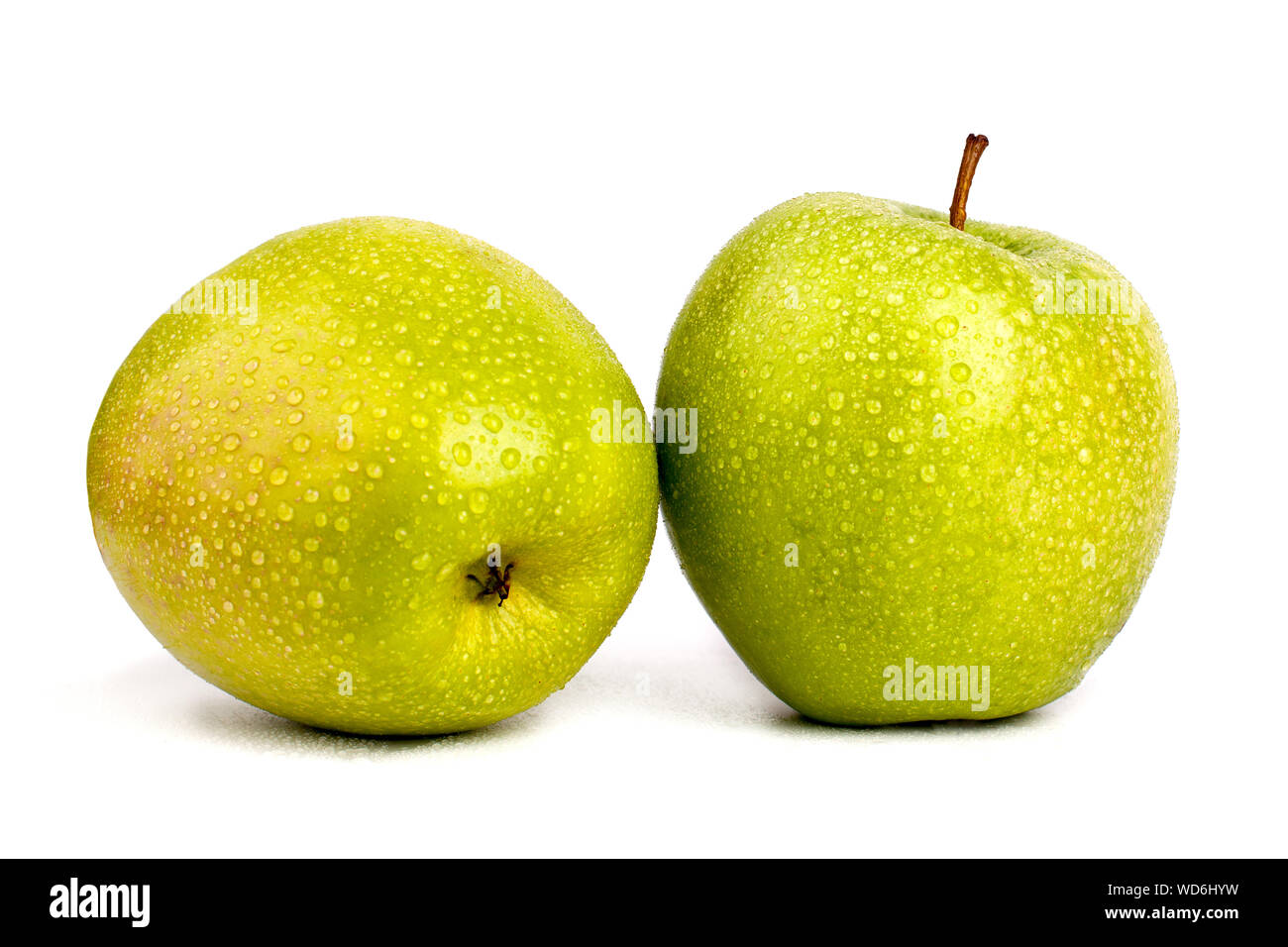 Deux pommes vertes juteuses en gouttes d'eau isolé sur fond blanc macro close up Banque D'Images