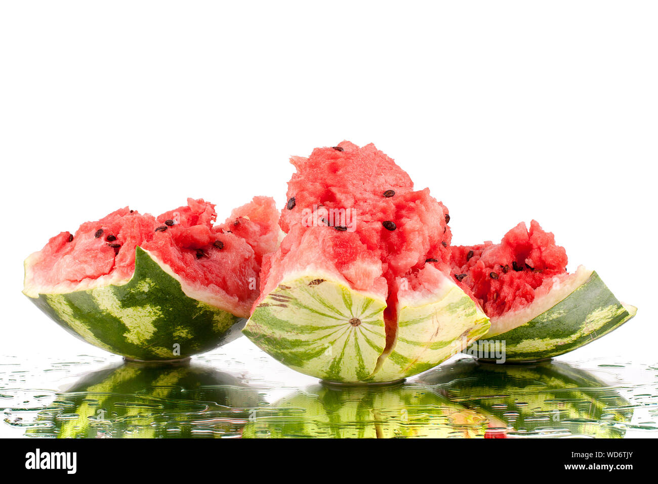 Watermelon morceaux cassés sur fond miroir blanc dans l'eau gouttes isolées close up Banque D'Images