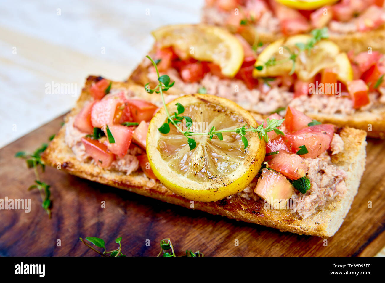 Bruschetta au thon apéritif et les tomates. La cuisine italienne. Délicieux antipasti italiens crostini sur planche de bois. Copier l'espace. Banque D'Images