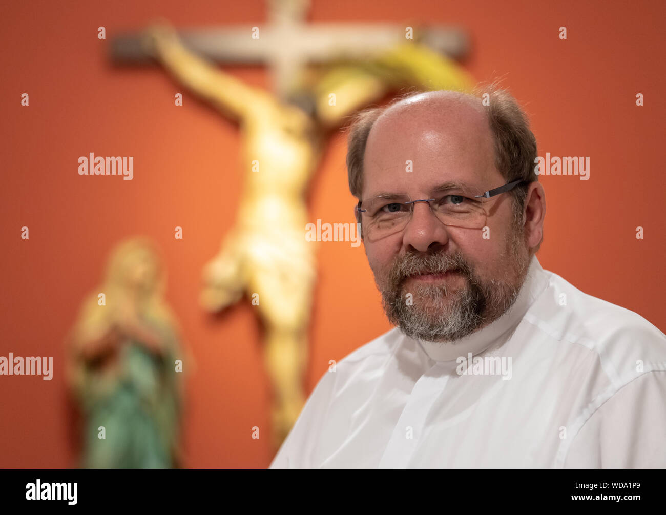 Munich, Allemagne. 31 juillet, 2019. L'évêque auxiliaire de l'archevêché de Munich et Freising, Wolfgang Bischof, se trouve dans le couloir de sa résidence officielle en face d'une croix de Jésus. Crédit : Peter Kneffel/dpa/Alamy Live News Banque D'Images